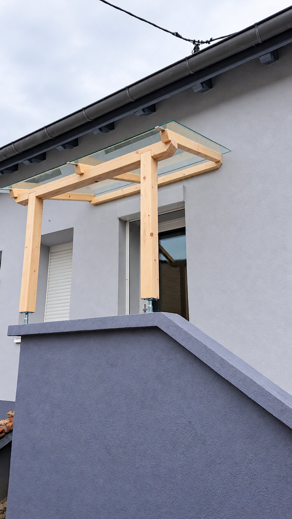 Auvent en bois et verre au-dessus d'une entrée de maison