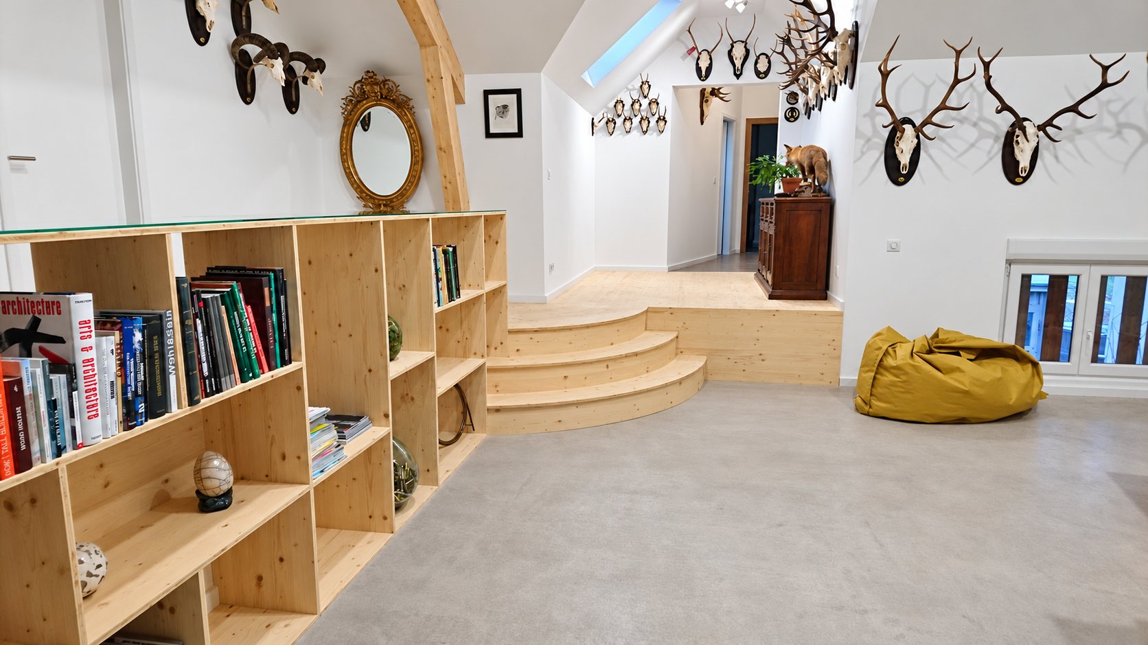Grande bibliothèque en bois clair devant des gradins dans un salon