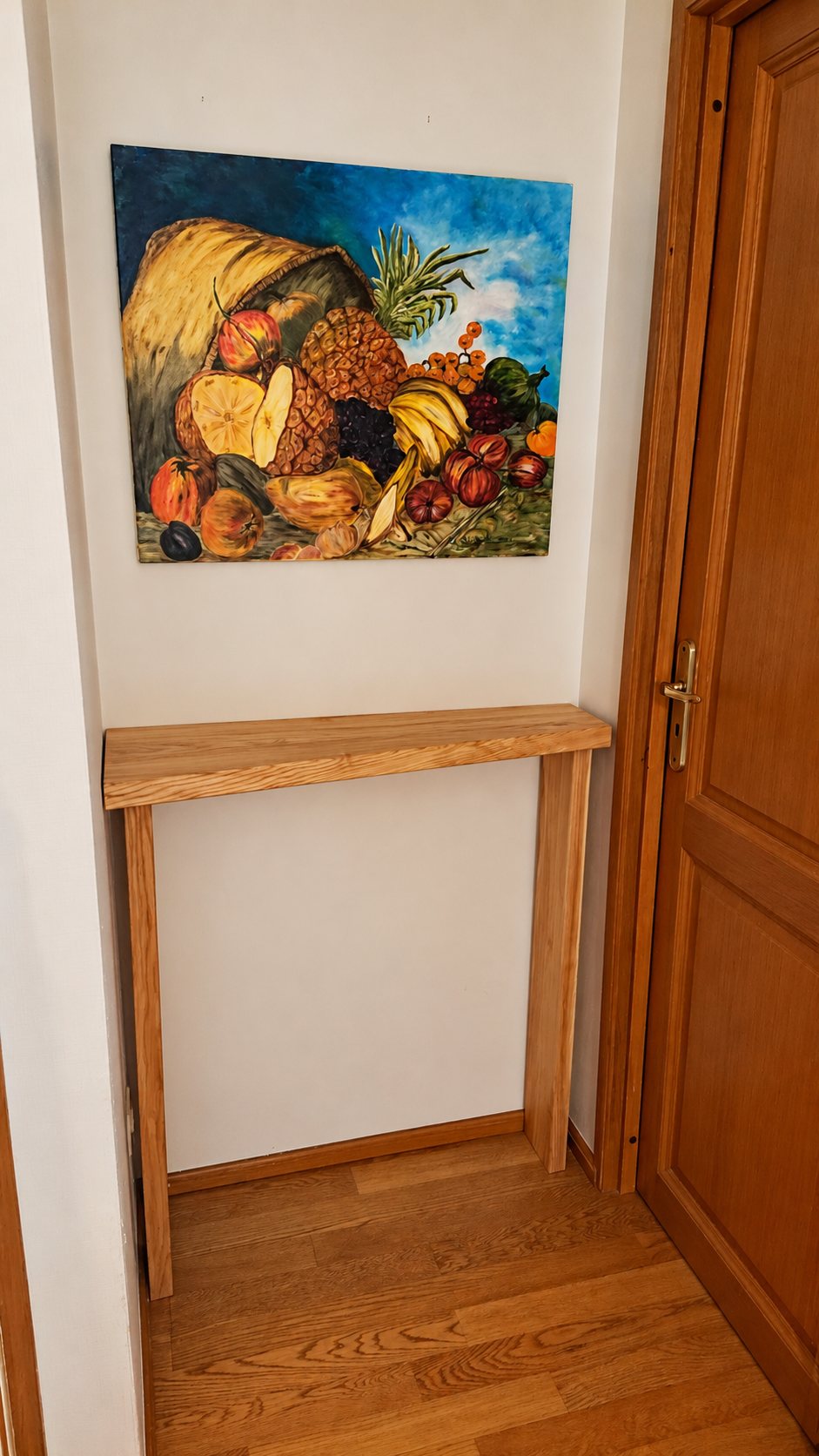Console murale en bois dans une entrée, près d'une porte en bois