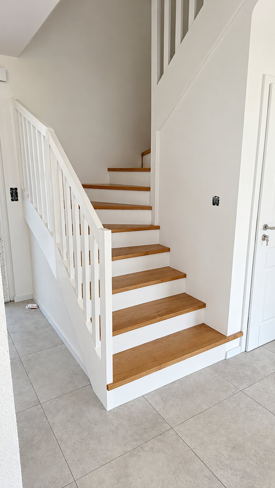 Escalier blanc à marches en bois et balustres blancs