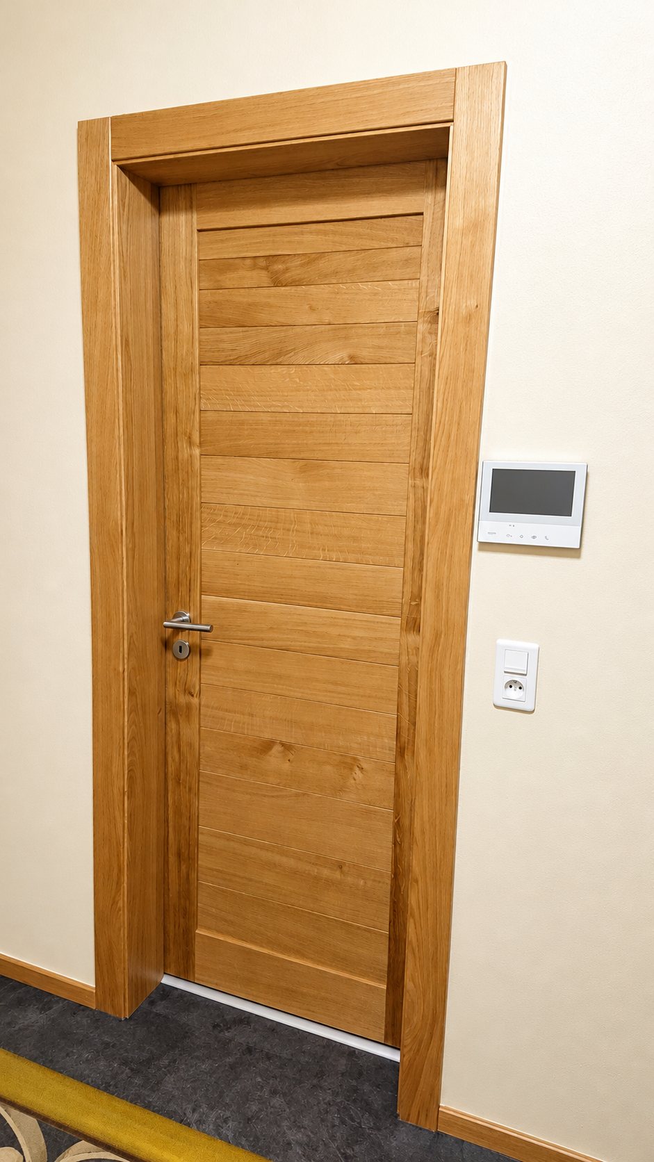 Porte en bois clair à encadrement bois dans un couloir