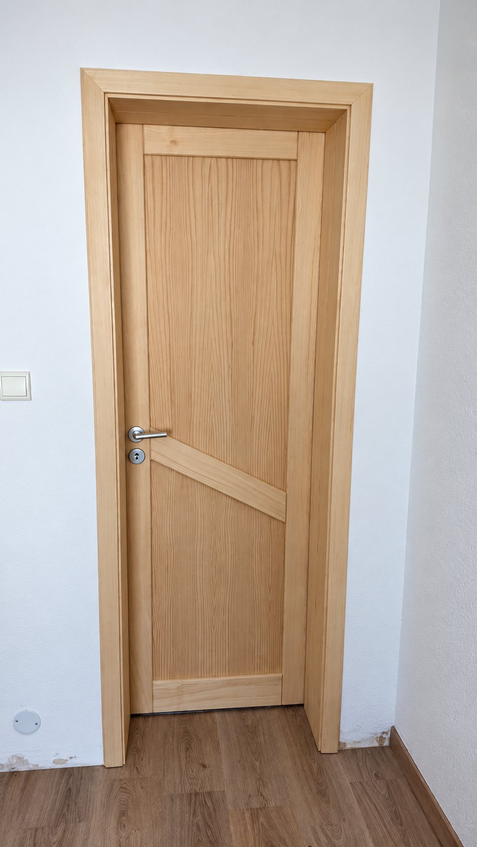 Porte en bois clair à panneaux et poignée alu