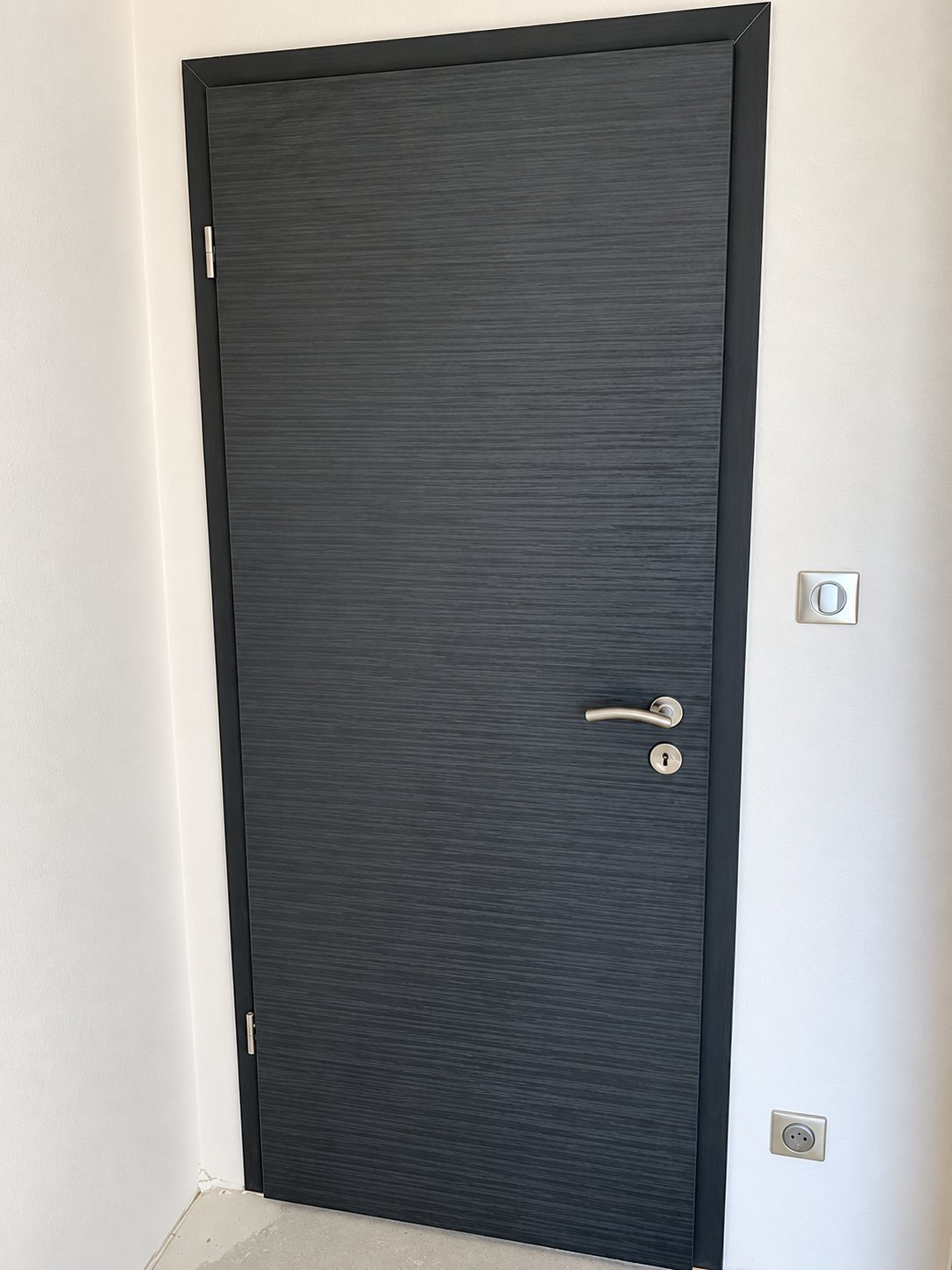 Porte en bois gris foncé texturé à cadre sombre
