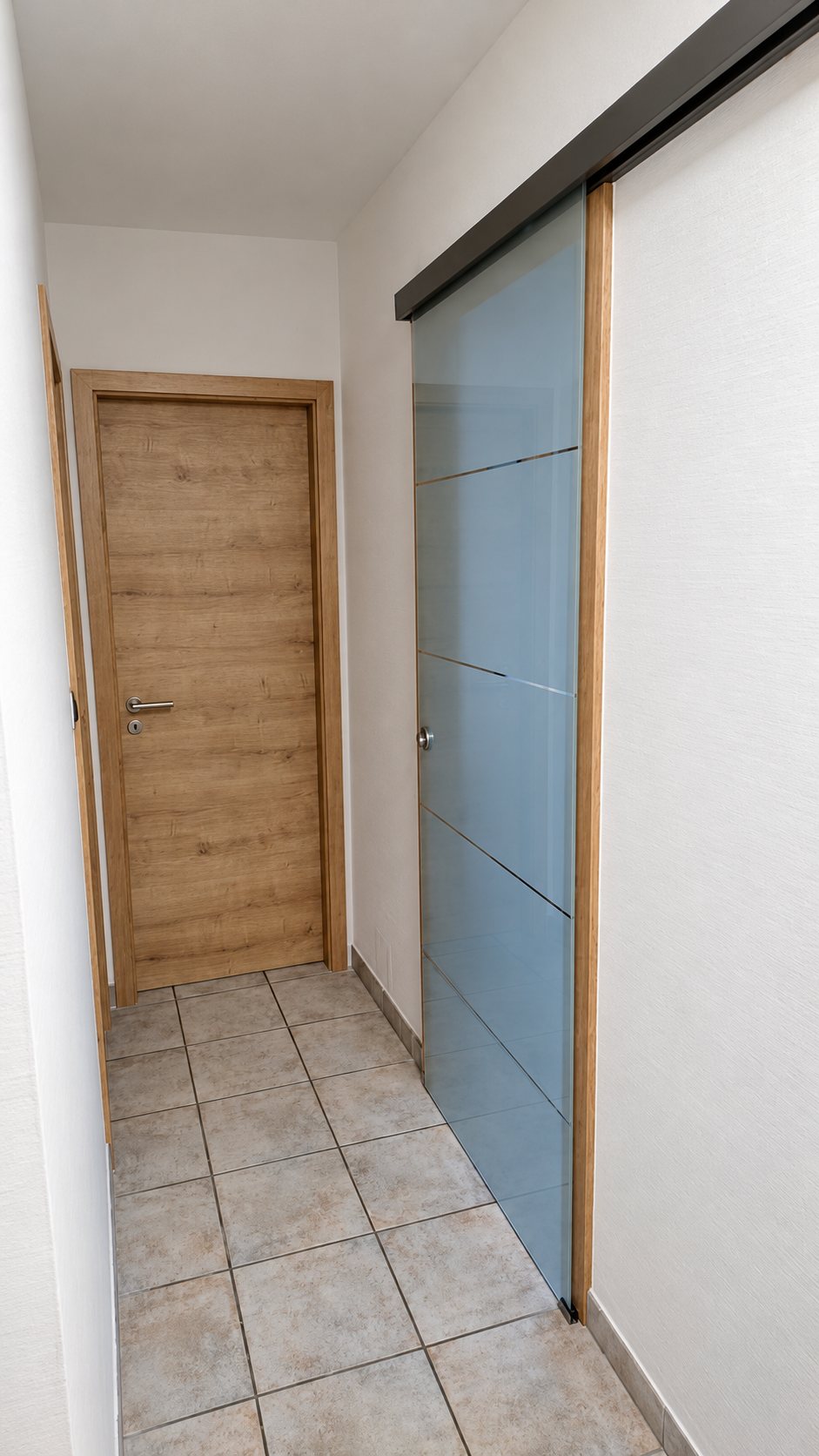Porte en bois travaillé à côté d'une porte coulissante vitrée