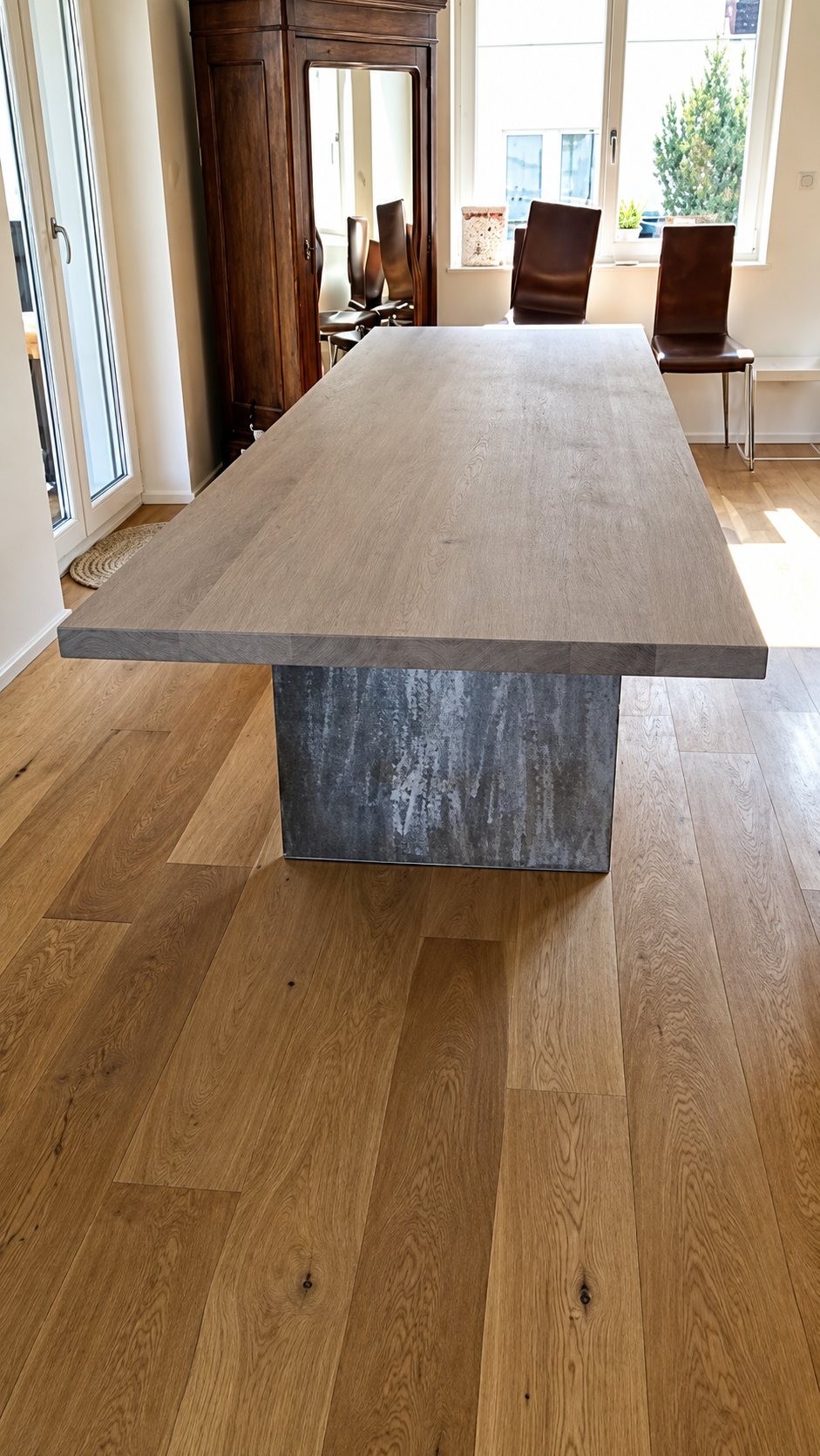 Longue table en chêne à pied en métal vieilli dans une salle à manger